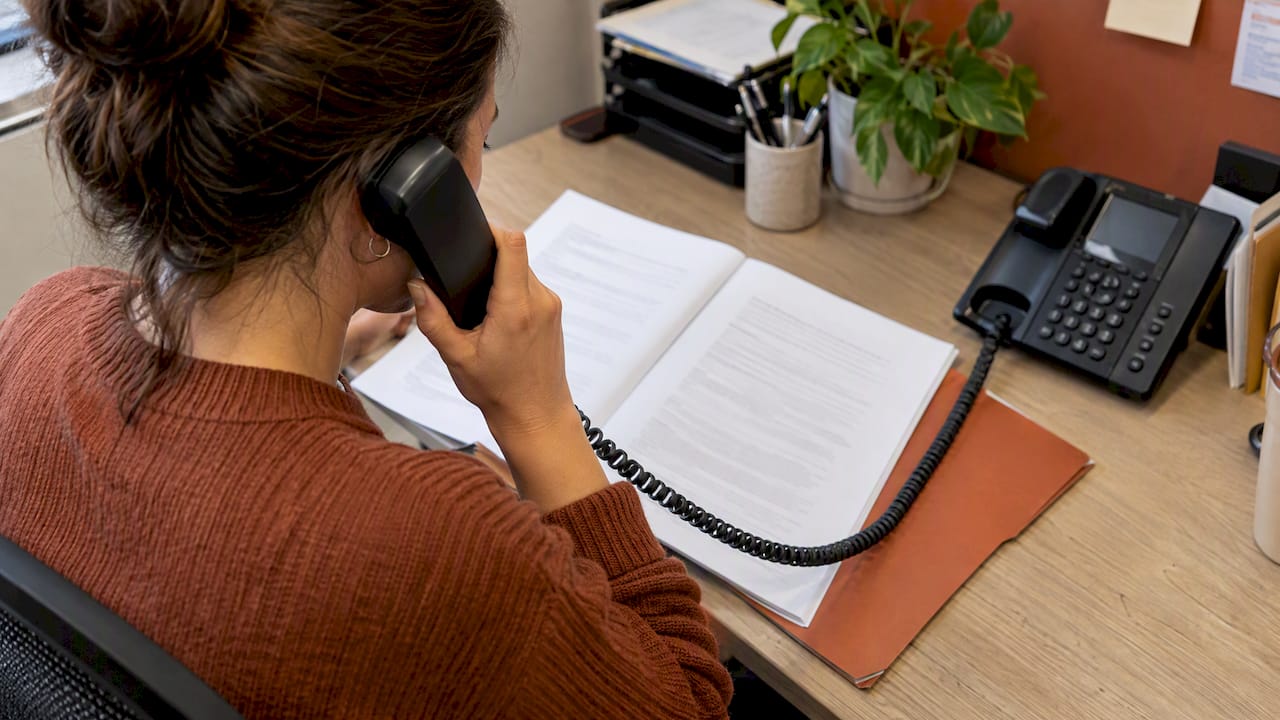 Appointment policy beside an office phone