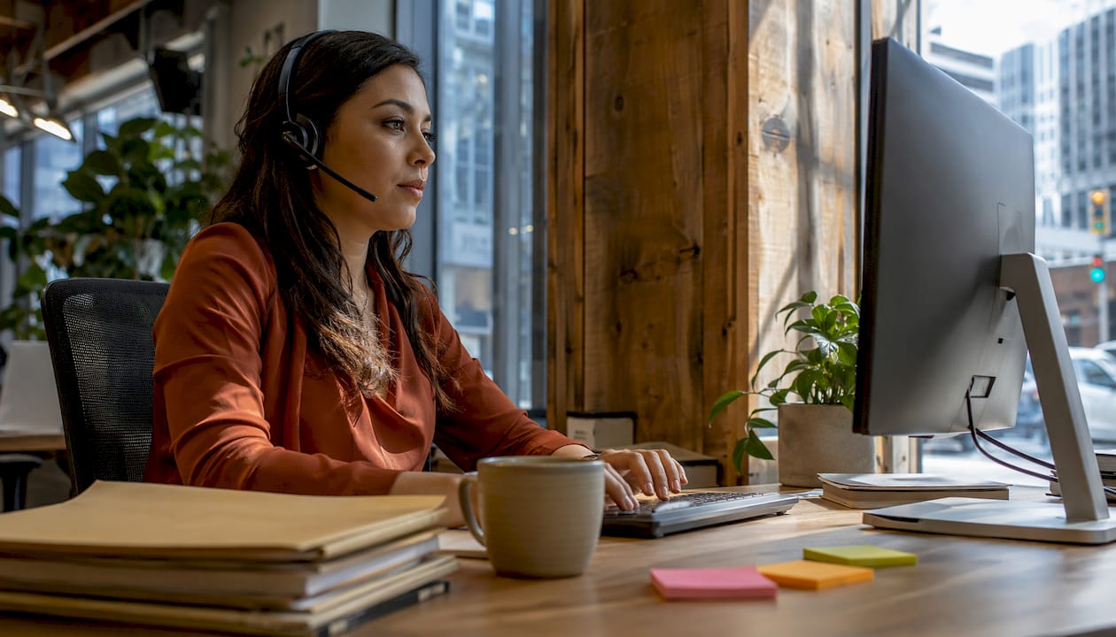 Legal secretary using AI receptionist software in office