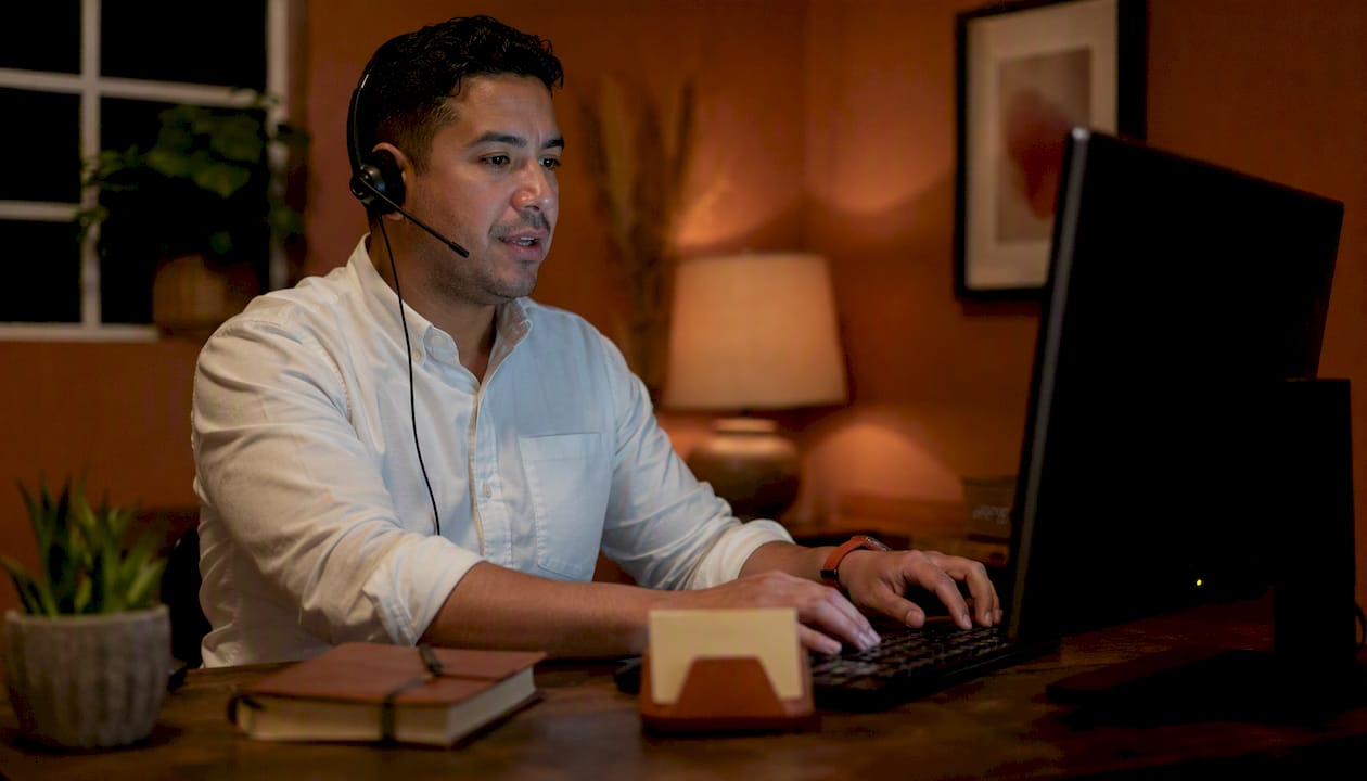 Recepcionista atendiendo una llamada telefónica de un paciente en español
