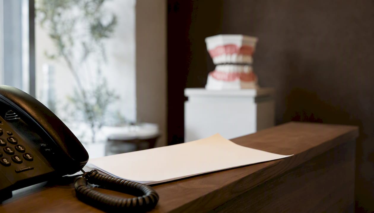 Dental office phone with Spanish script on desk