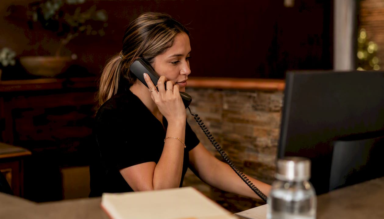 Hands holding phone receiver in business reception