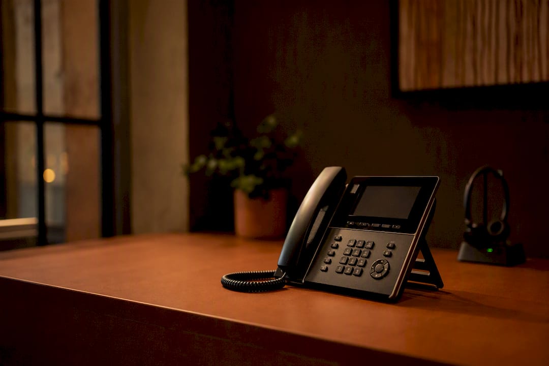 Close-up of office phone and headset on desk