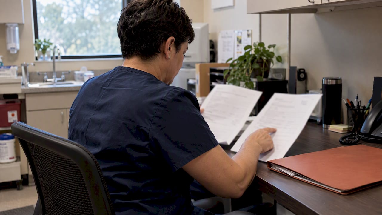 Clinic administrator reviewing bilingual contact forms