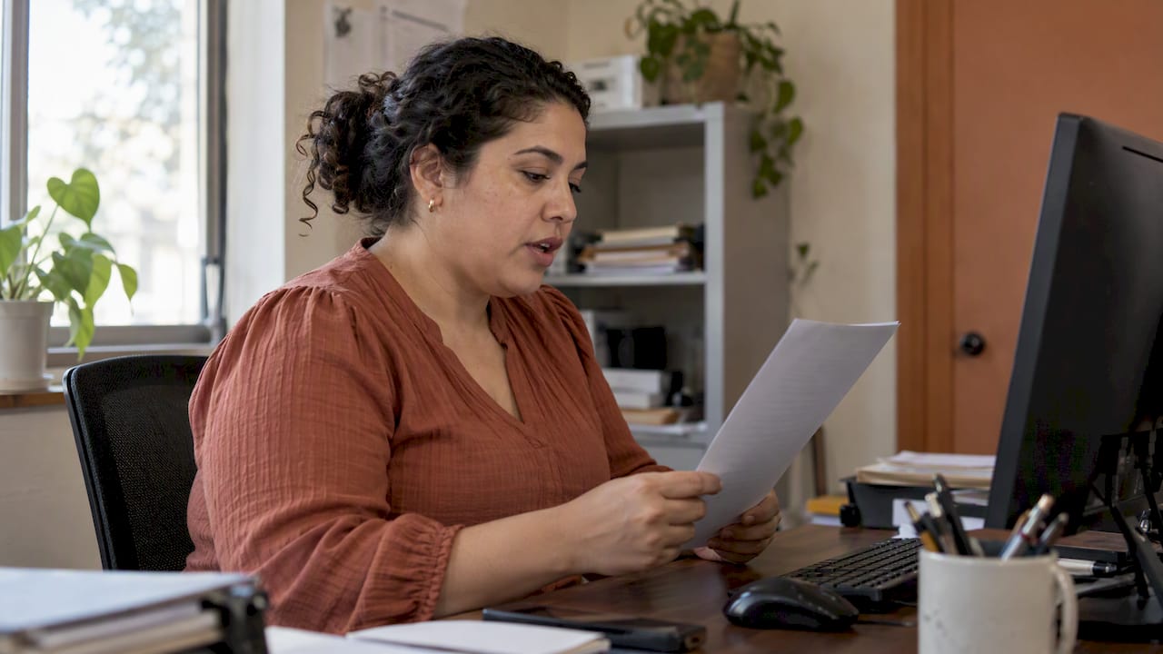 Clinic administrator reading Spanish website copy aloud
