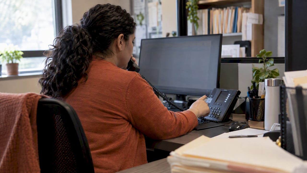 Clinic coordinator checking a Spanish voicemail transcript